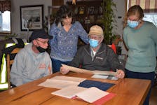 Troy Pratt (left), Stacey Culgin, Reg Culgin, and Mary Teed look over some Belmont Cemetery Corporation maps. Long-time map keeper Reg is passing the role over to newcomer Teed while Stacey also is moving on from her role as record keeper. Pratt, who has been digging graves for 42 years in Belmont, will continue with the job.
