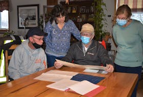 Troy Pratt (left), Stacey Culgin, Reg Culgin, and Mary Teed look over some Belmont Cemetery Corporation maps. Long-time map keeper Reg is passing the role over to newcomer Teed while Stacey also is moving on from her role as record keeper. Pratt, who has been digging graves for 42 years in Belmont, will continue with the job.