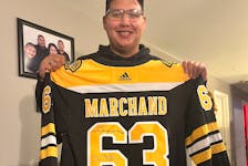 Logan Prosper of We'koqma'q First Nation proudly displays the signed jersey he received from his favourite hockey player, Brad Marchand of the Boston Bruins. CONTRIBUTED