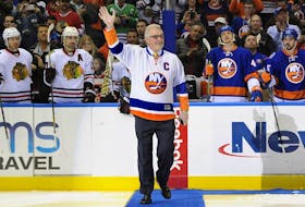 New York Islanders legend Clark Gillies waves to fans before conducting a ceremonial faceoff at Nassau Coliseum in Uniondale, N.Y., on Dec. 13, 2014.