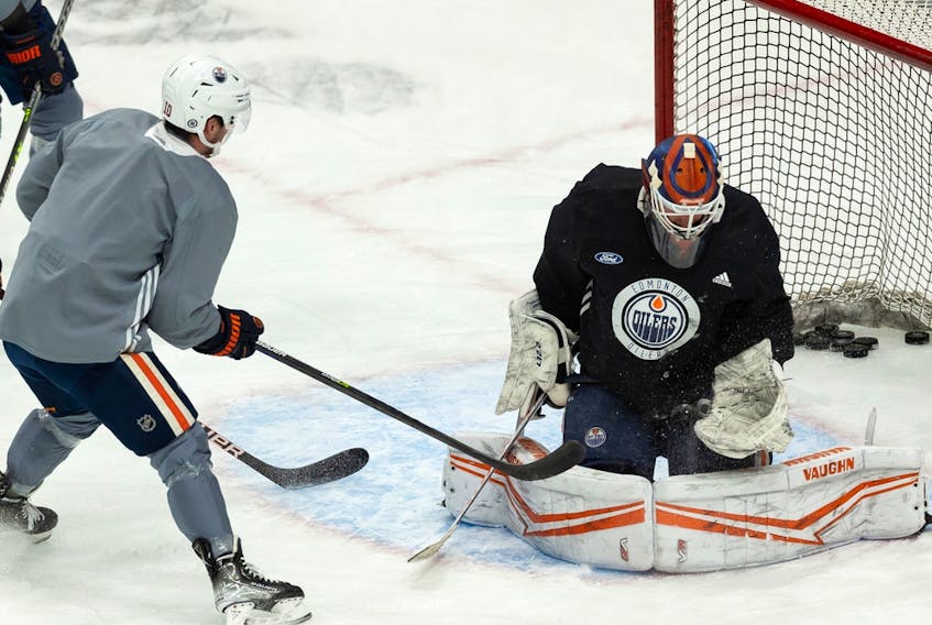 Edmonton Oilers goaltender Mikko Koskinen (19) makes a save on Derek Ryan (10) during practice at Rogers Place in Edmonton on Monday, Jan. 24, 2022.