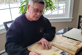 Wayne Schurman checks out a scrapbook that holds vital information on a former local championship team.