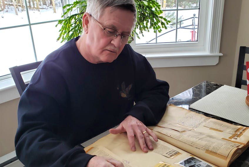 Wayne Schurman checks out a scrapbook that holds vital information on a former local championship team.