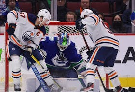 Vancouver Canucks goalie Spencer Martin stops Edmonton Oilers' Connor McDavid, left, and Kailer Yamamoto in Vancouver on Tuesday, Jan. 25, 2022.