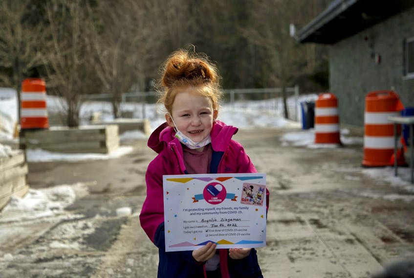 Brynlie Ziegeman, shows off the certificate and stickers she received after she got her first dose of COVID-19 vaccine at a pop-up clinic at the Keshen Goodman library in Halifax on Wednesday, Jan. 26, 2022.
