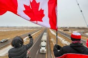  Supporters of the “freedom convoy” of truckers gathered on an overpass over the Trans-Canada Highway east of Calgary on Monday, January 24, 2022. The truckers are driving across Canada to Ottawa to protest the federal government’s COVID-19 vaccine mandate for cross-border truckers