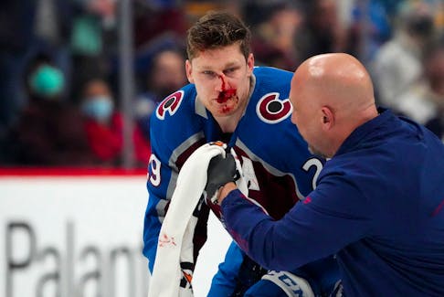 Colorado Avalanche center Nathan MacKinnon is treated for an injury in the first period against the Boston Bruins at Ball Arena on Wednesday.