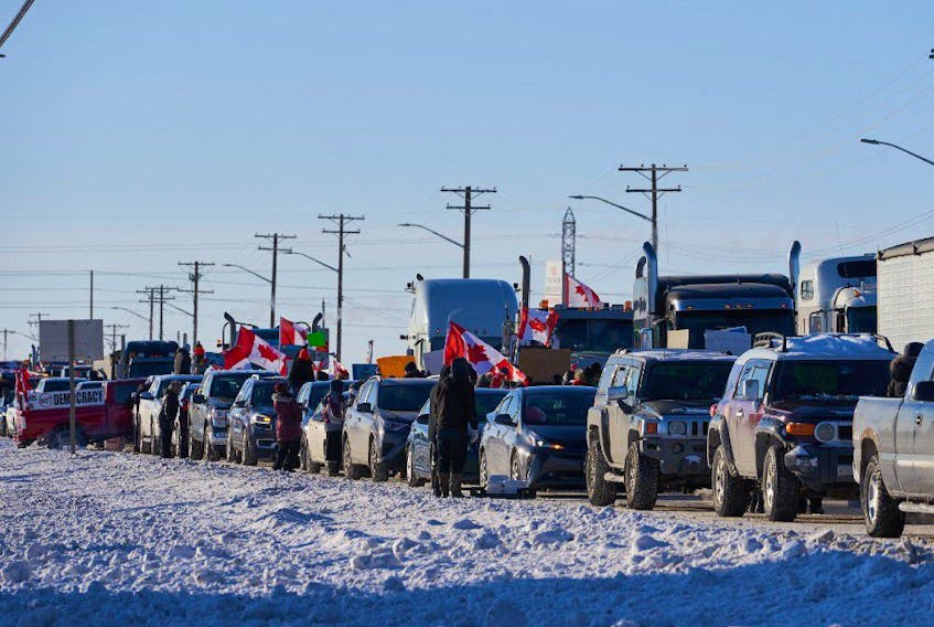 Protesters of COVID-19 restrictions, and supporters of Canadian truck drivers protesting the COVID-19 vaccine mandate cheer on a convoy of trucks on their way to Ottawa, on the Trans-Canada Highway west of Winnipeg, Manitoba, Tuesday January 25, 2022.