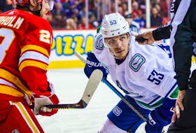 Canucks captain Bo Horvat, sidelined by COVID protocols, is expected to renew his rivalry with Elias Lindholm (left) and the Calgary Flames when he returns to the lineup Saturday and the teams face off in the Stampede City.