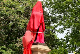 A statue of Canada's first Prime Minister, John A. Macdonald, is shrouded by Indigenous supporters at City Park in Kingston on Friday June 11, 2021.   