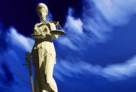 A Lady Justice sculpture depicts a blindfolded woman with sword and scale
