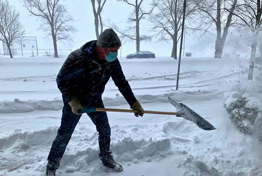 Todd Cranston, superintendent at Armoury Square in downtown Halifax, clears the entrance as an intense winter storm hit the province Saturday, Jan. 29, 2022.