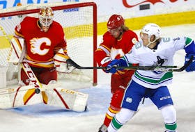 Calgary Flames goaltender Jacob Markstrom makes a save on a shot from the Vancouver Canucks’ Brock Boeser as the Flames’ Juuso Valimaki defends at Scotiabank Saddledome on May 19, 2021. 