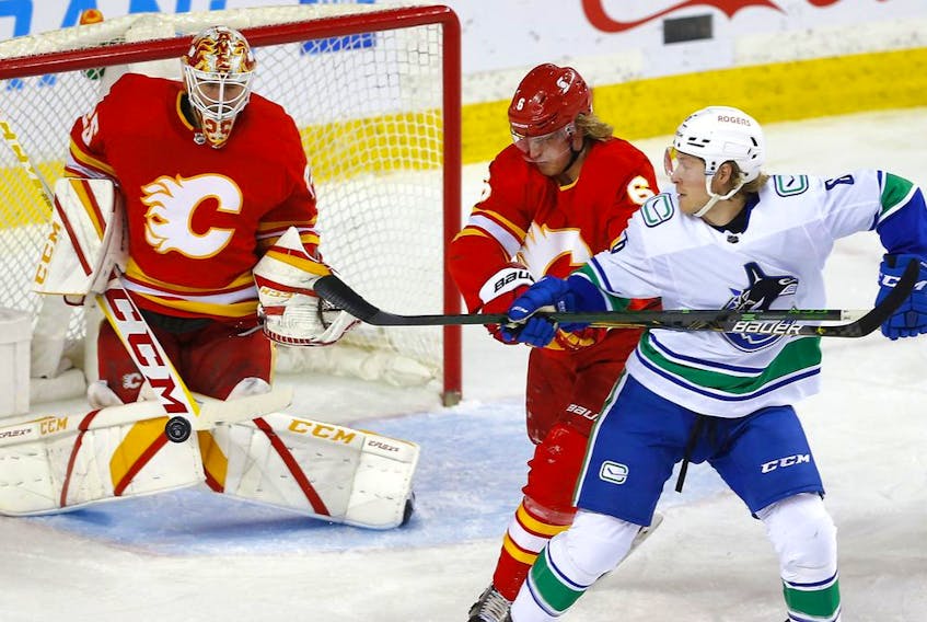 Calgary Flames goaltender Jacob Markstrom makes a save on a shot from the Vancouver Canucks’ Brock Boeser as the Flames’ Juuso Valimaki defends at Scotiabank Saddledome on May 19, 2021. 