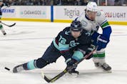  Seattle Kraken right wing Joonas Donskoi (72) and Vancouver Canucks defenseman Quinn Hughes (43) battle for the puck during the second period at Climate Pledge Arena.