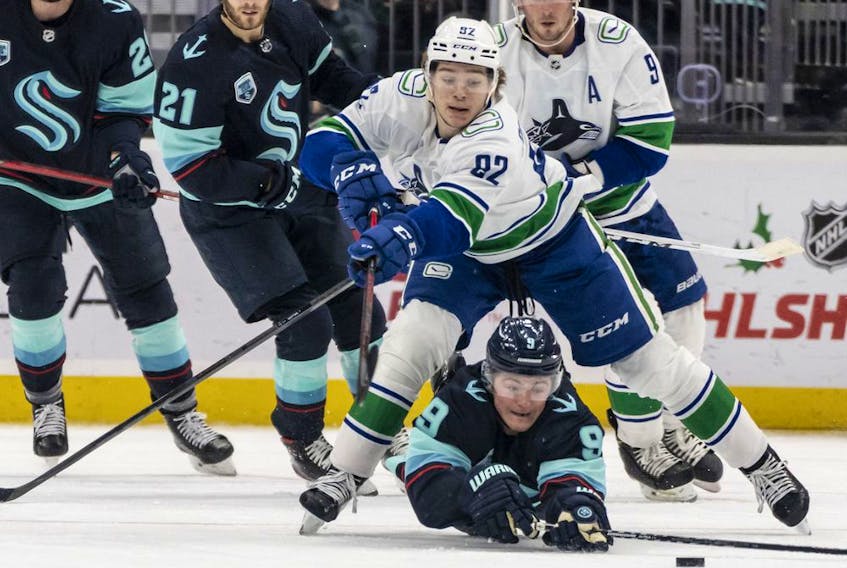  Seattle Kraken centre Ryan Donato (9) passes the puck as he goes to the ice against Vancouver Canucks right wing Vasily Podkolzin (92) during the second period at Climate Pledge Arena.