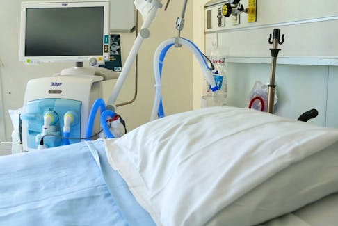 A ventilator stands beside a bed in an intensive care unit - File