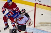 Montreal Canadiens' Mathieu Darche screens New Jersey Devils' Martin Brodeur as Lars Eller's shot finds the net at the Bell Centre in Montreal on Dec. 17, 2011.