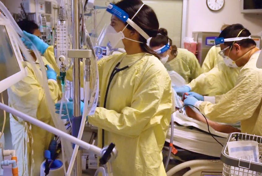  Teams in a crowded Calgary intensive care unit tend to a COVID-19 patient on a ventilator in 2021.