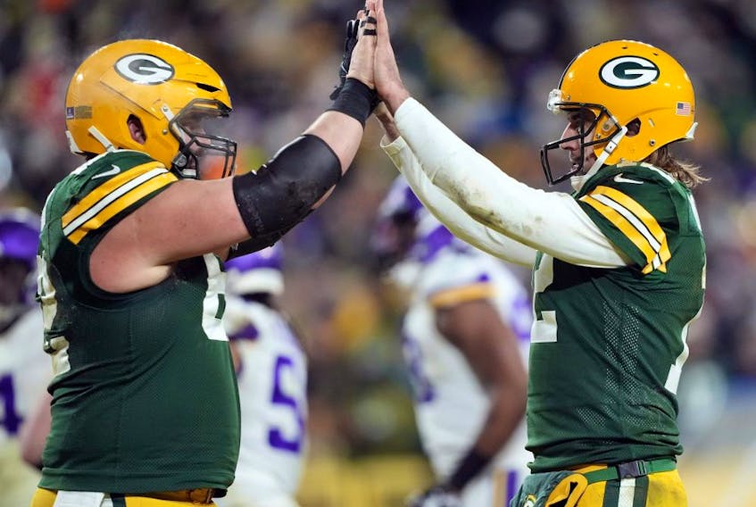 Quarterback Aaron Rodgers of the Green Bay Packers (right) is congratulated by centre Lucas Patrick after a touchdown during the fourth quarter of their team's game against the Minnesota Vikings at Lambeau Field on Jan. 2, 2022 in Green Bay, Wisconsin. 