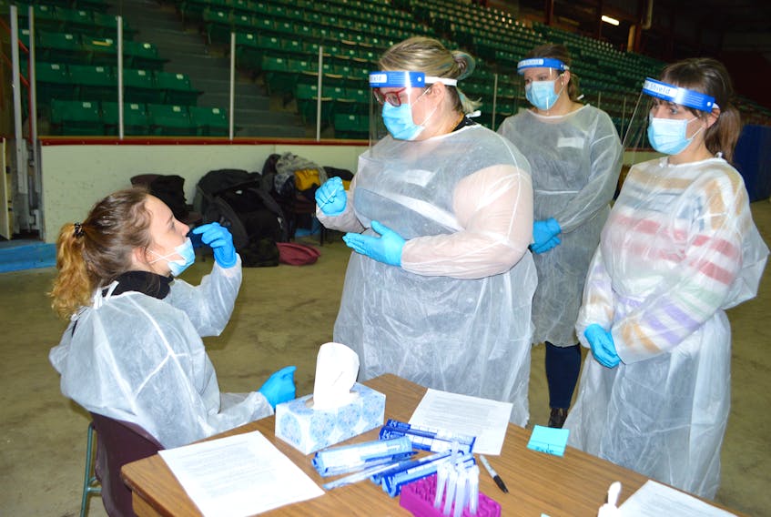 In this file photo from January 2021, Ava Block, seated, a trainer with Praxes Medical Group in Halifax, shows Sarah Munroe of Sydney how to do a swabbing for a COVID-19 test. Block was training volunteers prior to the pop-up rapid community testing site at the Canada Games Complex at Cape Breton University. SHARON MONTGOMERY-DUPE/CAPE BRETON POST 