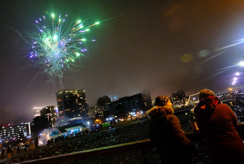 A couple enjoys some wine, as fireworks in backdropped by the Halifax skyline, as they welcome in the New Year on the waterfront January 1, 2022.

TIM KROCHAK