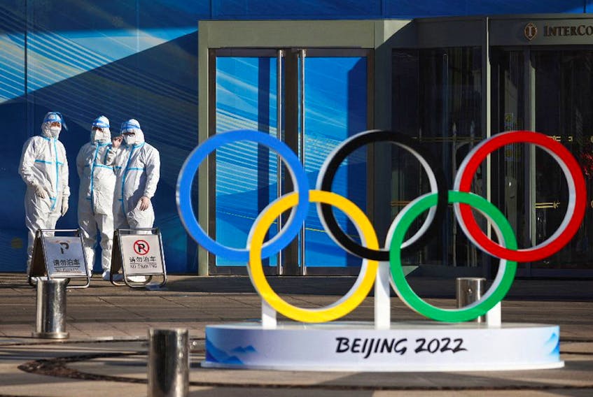  Workers in PPE stand next to the Olympic rings inside the closed loop area near the National Stadium, or the Bird’s Nest, where the opening and closing ceremonies of Beijing 2022 Winter Olympics will be held, in Beijing, China.