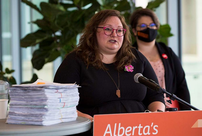  NDP Education Critic Sarah Hoffman, left, and concerned parent Taylor Schroeter with a petition calling on the UCP to scuttle its K-6 curriculum draft. The two appeared at a press conference in Edmonton on Wednesday, April 28, 2021.