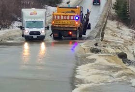 This image taken from a video recorded by Michael Childs shows water flowing over Route 450 on the south shore of the Bay of Islands at Madore’s Brook on Thursday, Dec. 6. The road was later closed to traffic, cutting off the communities of Lark Harbour and York Harbour.