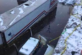 This photo of the semi-submerged transport truck that left Highway 105 near Baddeck was posted to social media Saturday. AARON MACKENZIE/FACEBOOK