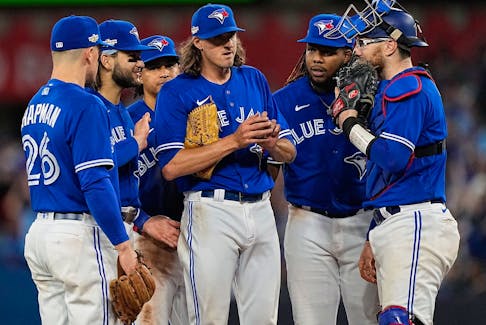 Oct 8, 2022; Toronto, Ontario, CAN; Toronto Blue Jays starting pitcher Kevin Gausman is surrounded by teammates before he gets pulled in the sixth inning against the Seattle Mariners during game two of the Wild Card series for the 2022 MLB Playoffs at Rogers Centre.  