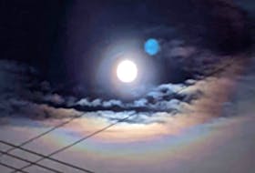 Chris Young shared this photo of the full moon over the long weekend with some faint rainbow colours on the cloud below it. -Contributed.