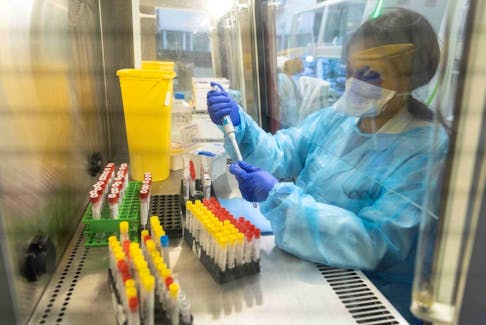 Laboratory operator handles positive Covid-19 samples to be sequenced in the virology laboratory of the AP-HP Henri Mondor Hospital in Creteil, on the outskirt of Paris on December 7, 2021. (Photo by THOMAS SAMSON/AFP via Getty Images)