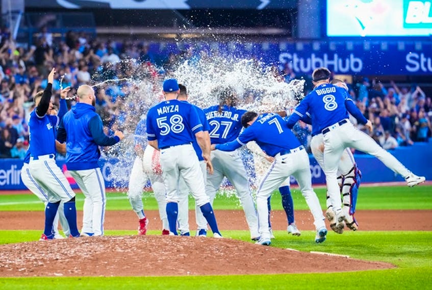 TORONTO, ON - SEPTEMBER 26: Teammates splash Vladimir Guerrero Jr. #27 of the Toronto Blue Jays with water after his walk-off hit to defeat the New York Yankees in the tenth inning during their MLB game at the Rogers Centre on September 26, 2022 in Toronto, Ontario, Canada. (Photo by Mark Blinch/Getty Images)