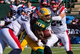 Edmonton Elks running back Kevin Brown (4) is tackled by Montreal Alouettes defensive lineman Michael Wakefield (96) at Commonwealth stadium in Edmonton on Saturday, Oct. 1, 2022.