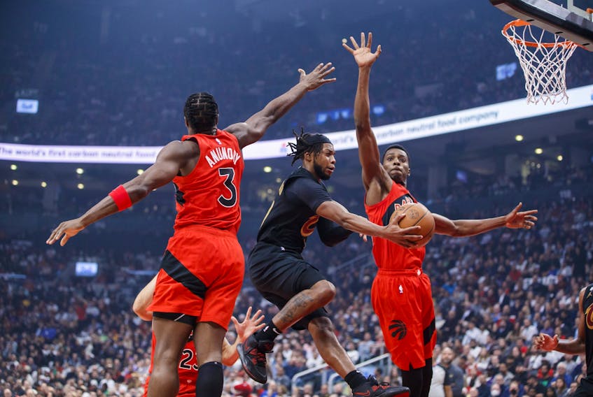 Raptors rookie Christian Koloko (right) goes up with O.G. Anunoby to defend against Darius Garland of the Cavaliers in Wednesday’s opener at Scotiabank Arena. The 7-foot-1 Koloko made an instant impact in his 14 minutes on the floor.  