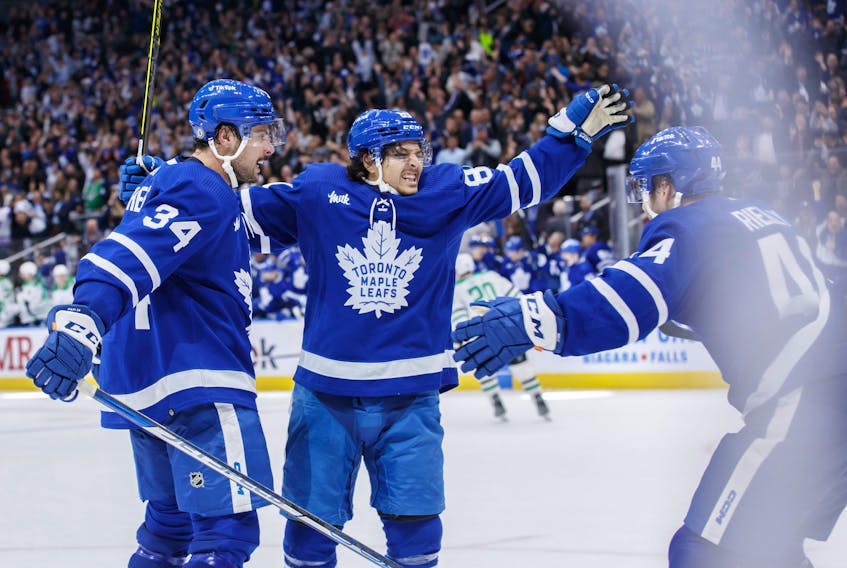 Maple Leafs' Nick Robertson (89), centre Auston Matthews (34) and defenceman Morgan Rielly celebrate Robertson's overtime goal against the Dallas Stars in Toronto on Thursday, Oct. 20, 2022. 