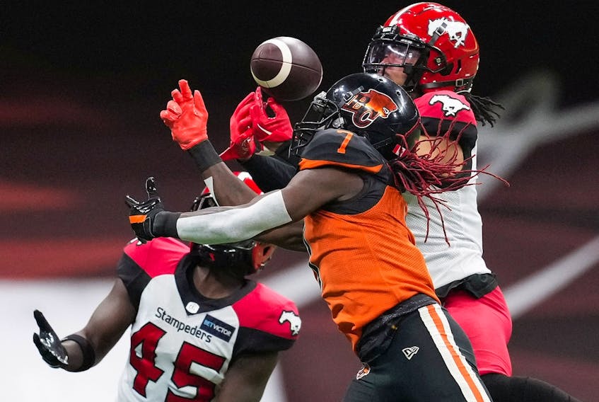  The B.C. Lions’ Lucky Whitehead fails to make the reception as the Calgary Stampeders’ Javien Elliott, back right, and Trumaine Washington defend at BC Place in Vancouver on Sept. 24, 2022.