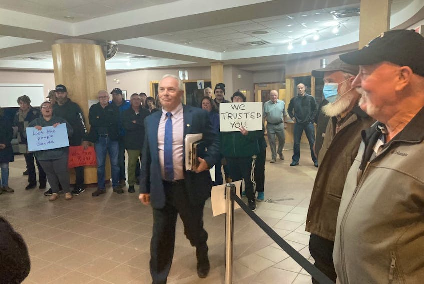 Antigonish County Warden Owen McCarron walks past protesters to vote on the consolidation of the town and county of Antigonish. AARON BESWICK