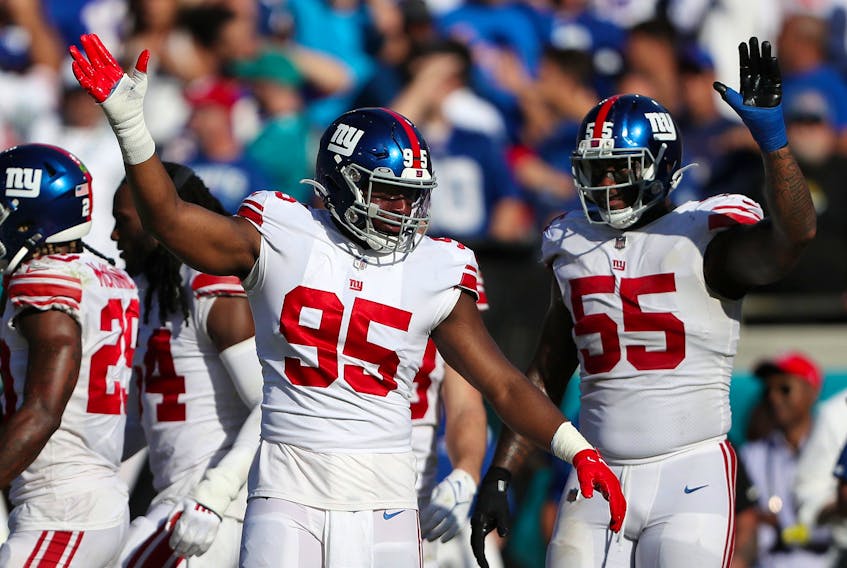 Quincy Roche #95 and Jihad Ward #55 of the New York Giants react after a stop in the fourth quarter against the Jacksonville Jaguars.