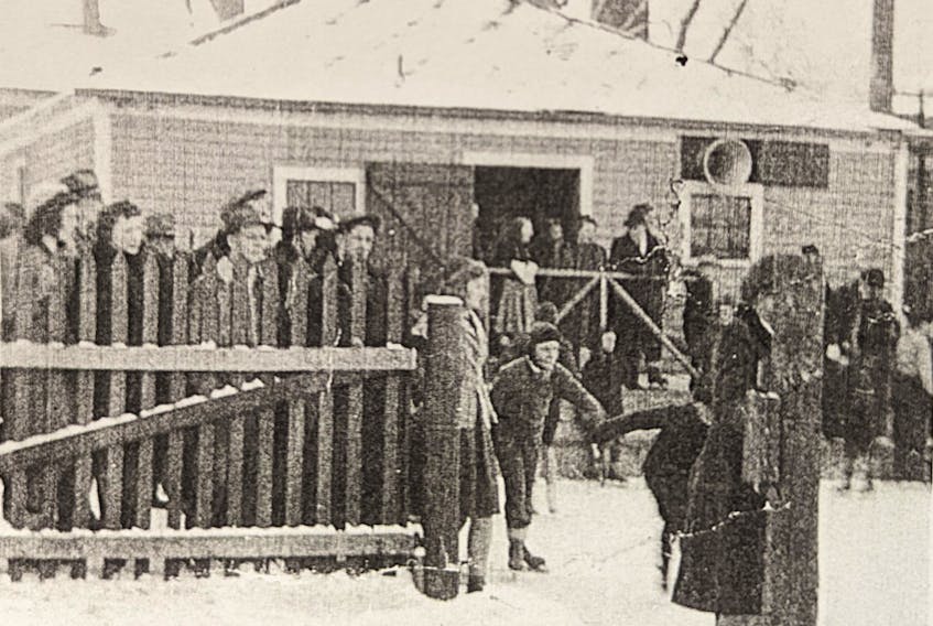 A skating party eagerly waits outside the dressing room building to enter the ice at Hamilton's Rink off Walker Street in Truro.