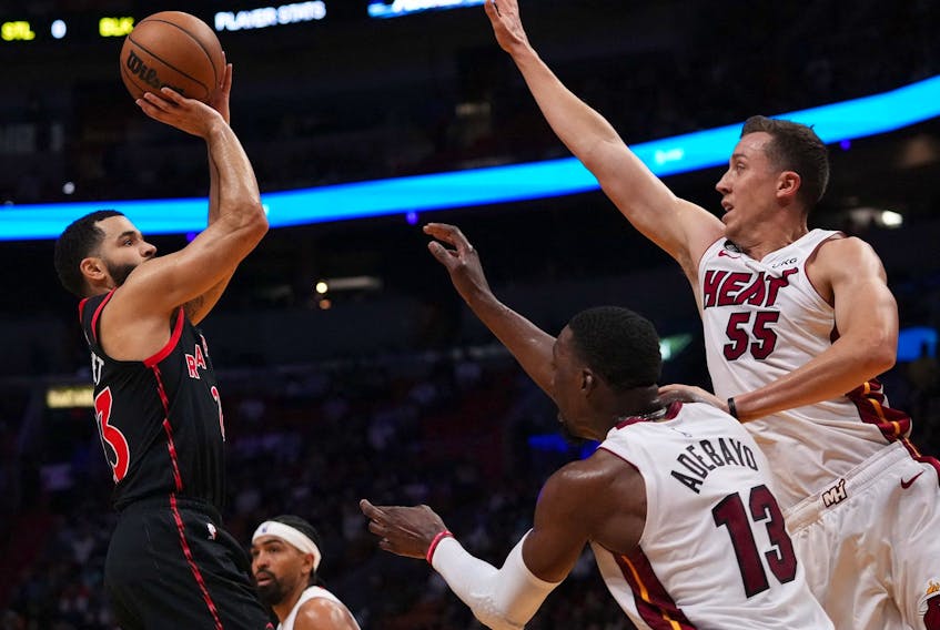 Raptors guard Fred VanVleet (23) shoots the ball over center Bam Adebayo (13) and Miami Heat guard Duncan Robinson (55) during the first half in Miami on Monday night. 
