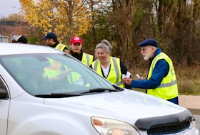 Rotarians Jo Gould-Thorpe and Andy Kirk were among the volunteers who took the early shift at the toll road on Oct. 15, helping collect donations for the Matthew 25 Windsor and District Food Bank.