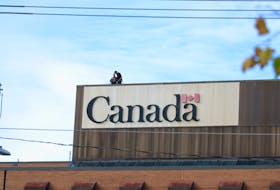 Contractors conduct repairs on top of the Daniel J. MacDonald building, headquarters of Veterans Affairs Canada, in Charlottetown on October 25. - Stu Neatby