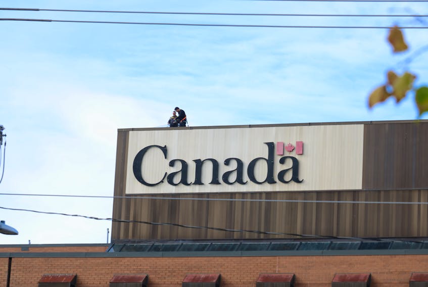 Contractors conduct repairs on top of the Daniel J. MacDonald building, headquarters of Veterans Affairs Canada, in Charlottetown on October 25. - Stu Neatby