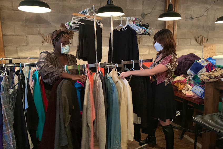 Chanel Briggs, right, and, Nouhad Mourad, of BIPOC USHR and Charlottetown Mutual Aid, go through clothing inventory on Oct. 19, 2022, at the organization's temporary location on Richmond Street. Terrence McEachern • The Guardian