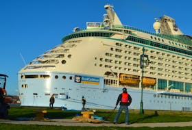 Stevedores are shown tying down the massive cruise ship Voyager of the Seven Seas on Friday. The 677-foot vessel had to be secured to multiple spots along the main terminal dock and at points on shore before its estimated 700 passengers began their tour of Cape Breton. GREG MCNEIL/CAPE BRETON POST