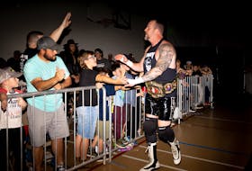 “Kowboy” Mike Hughes, founder and operator of Red Rock Wrestling, greets fans on the way to the ring at an October event in Stratford, the last for Hughes before his retirement. - Shane Wilkie • Special to The Guardian