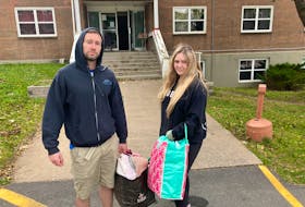 Tienna MacKenzie and Alex Power are shown picking up their belongings at the pair's former Dartmouth apartment on Sunday.