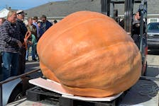 John Porter (left) watches as his prize winning 1,400 pound pumpkin is unloaded from his trailer at the annual Clark’s Harbour Pumpkin and Squash Weigh-in on Oct. 2. KATHY JOHNSON